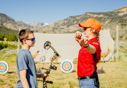 Game and Fish hunter education instructor gives archery tips to a bowhunter education student.