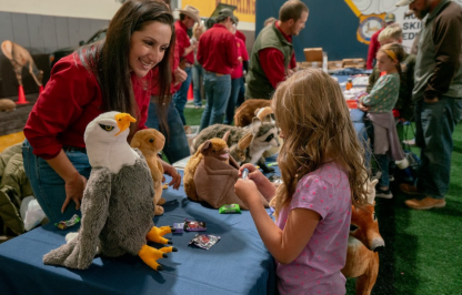 Kids interacting with Game and Fish employee at UW game